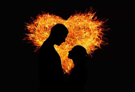 Couple with a flaming heart behind them.